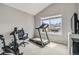 Home exercise room featuring a treadmill and spin bike, and a large window providing natural light at 12551 W 84Th Cir, Arvada, CO 80005