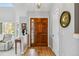 Welcoming foyer with hardwood floors, a decorative front door, and a cozy sitting area at 12551 W 84Th Cir, Arvada, CO 80005