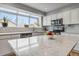 Bright kitchen features white cabinetry, stainless appliances, quartz countertops, and natural light from a large window at 12551 W 84Th Cir, Arvada, CO 80005