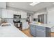 Bright kitchen with white cabinets, stainless appliances, island, and hardwood floors at 12551 W 84Th Cir, Arvada, CO 80005