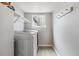 Clean laundry room with modern washer/dryer, shelving, window and coat hooks at 12551 W 84Th Cir, Arvada, CO 80005