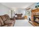 Warm living room with a brick fireplace, plush furniture, and natural light at 12551 W 84Th Cir, Arvada, CO 80005