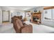 Cozy living room features a brick fireplace, plush seating and a bright window at 12551 W 84Th Cir, Arvada, CO 80005