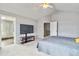 Spacious main bedroom with carpet, ceiling fan, a tv, and large opening to the main bathroom at 12551 W 84Th Cir, Arvada, CO 80005
