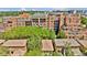 Aerial view of a multi-story brick building surrounded by lush greenery and neighborhood homes at 100 S University Blvd # 4, Denver, CO 80209