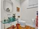 Modern bathroom with a glass bowl sink, artistic mirror, stylish fixtures, toilet and hardwood floors at 100 S University Blvd # 4, Denver, CO 80209