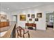 Hallway with carpet, artwork and dark railings leading to a bedroom with furniture at 100 S University Blvd # 4, Denver, CO 80209