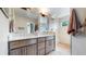 Modern bathroom featuring double sinks, wooden cabinets, a glass shower door, and updated fixtures at 1426 S Pearl St, Denver, CO 80210
