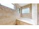Elegant bathtub with stone tile surround, a clear glass shower door, and multiple windows at 1426 S Pearl St, Denver, CO 80210