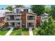 Contemporary home with stone and wood accents, showcasing balconies and landscaped front yard at 1426 S Pearl St, Denver, CO 80210
