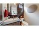 Modern powder room featuring custom sink, dark cabinets, a basket of towels and textured accent wall at 1426 S Pearl St, Denver, CO 80210