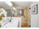 Bright bathroom featuring a glass enclosed shower, tiled walls, and a modern vanity with white countertop at 1469 S Lincoln St, Denver, CO 80210