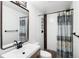 Bathroom featuring wood look vanity with dark fixtures, patterned shower curtain and pebble floor at 1469 S Lincoln St, Denver, CO 80210