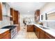 Long kitchen view with wood cabinets, stainless steel appliances, and view into dining room at 1469 S Lincoln St, Denver, CO 80210