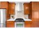 Kitchen featuring stainless steel appliances, wood cabinets, quartz countertops, and tile backsplash at 1469 S Lincoln St, Denver, CO 80210