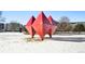 Red geometric sculptures in a snowy park setting at 2 Adams St # 1010, Denver, CO 80206