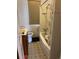Compact bathroom with a shower-tub combo, vintage-style tiling, and classic fixtures at 3036 W Clyde Pl, Denver, CO 80211