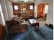 Cozy living room featuring classic wood paneling, comfortable seating, and blue carpet at 3036 W Clyde Pl, Denver, CO 80211