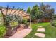 Charming backyard oasis with a pergola covered seating area, brick patio and stepping stones at 3752 S Helena Way, Aurora, CO 80013