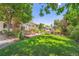 Beautifully landscaped backyard with a brick patio, lush lawn, and mature trees at 3752 S Helena Way, Aurora, CO 80013