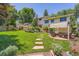 Lush backyard with patio, pergola seating area, stone walkway, and mature trees at 3752 S Helena Way, Aurora, CO 80013