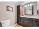 Bathroom with a modern vanity, framed mirror, toilet, and wood-look flooring at 3752 S Helena Way, Aurora, CO 80013