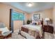 This bedroom features a comfortable bed, chair and a window letting in lots of light at 3752 S Helena Way, Aurora, CO 80013