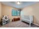 This bedroom includes a crib, toy kitchen, and a window letting in lots of natural light at 3752 S Helena Way, Aurora, CO 80013
