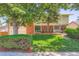 Brick home with lush front lawn, mature trees, and a cozy porch swing for relaxed outdoor living at 3752 S Helena Way, Aurora, CO 80013