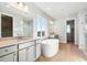 Bright bathroom features a soaking tub, double vanity, and a glass shower at 1784 Morgan Dr, Erie, CO 80516