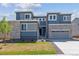 New construction home featuring stone accents, gray two-car garage and a manicured lawn at 1784 Morgan Dr, Erie, CO 80516