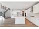 Bright kitchen featuring white cabinetry, an island, and stainless steel appliances with a staircase view at 1784 Morgan Dr, Erie, CO 80516