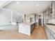Open-concept kitchen flowing into the living area, featuring an island and modern cabinets at 1784 Morgan Dr, Erie, CO 80516