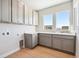 Bright laundry room with modern cabinets, stone countertops, and a sink at 1784 Morgan Dr, Erie, CO 80516