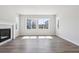 Bright living room featuring a fireplace, hardwood floors, and large windows with plenty of natural light at 1784 Morgan Dr, Erie, CO 80516