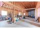 Open garage with high ceilings, exposed wooden beams, concrete flooring, and a large door to the exterior at 409 N Garden Ct, Platteville, CO 80651