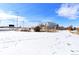 Exterior view of the property backing onto community baseball/softball field in a snowy landscape at 409 N Garden Ct, Platteville, CO 80651
