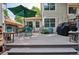 Wide view of the backyard deck with seating, a grill, and flowering plants along the side of the house at 1563 S Trenton Ct, Denver, CO 80231