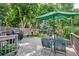 The backyard deck features ample space for entertaining, including a grill, bench, and outdoor dining set under a green umbrella at 1563 S Trenton Ct, Denver, CO 80231