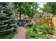 Cozy backyard with vibrant blue chairs set amidst lush greenery, gravel path, and a charming garden at 1563 S Trenton Ct, Denver, CO 80231