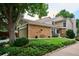 Charming two-story home featuring brick accents, an attached garage, and mature landscaping at 1563 S Trenton Ct, Denver, CO 80231