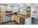 Well-lit kitchen features stainless steel appliances, tile backsplash, and light wood cabinetry at 1563 S Trenton Ct, Denver, CO 80231