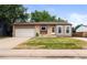 Single-Gathering home featuring a grass yard and attached one car garage in a residential neighborhood at 5167 Sable St, Denver, CO 80239