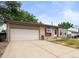 Tan home featuring a brick facade and attached one car garage with well-kept lawn at 5167 Sable St, Denver, CO 80239