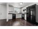 Kitchen featuring sleek black appliances, white cabinets, and dark countertops with hardwood flooring at 5167 Sable St, Denver, CO 80239