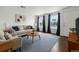 Bright living room with large windows, a comfortable couch, and a stylish round wood coffee table at 5167 Sable St, Denver, CO 80239