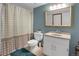 This bathroom features a shower with a patterned curtain, an ornate mirror, and a white vanity at 18553 County Road 5, Berthoud, CO 80513