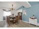 Dining area with seating for eight features a hutch and modern chandelier lighting at 18553 County Road 5, Berthoud, CO 80513