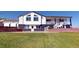 Charming two-story home with white facade, black accents, and a lush green lawn at 18553 County Road 5, Berthoud, CO 80513
