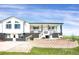 Charming two-story home with a brick foundation and inviting white porch and stairs with decorative statuary at 18553 County Road 5, Berthoud, CO 80513